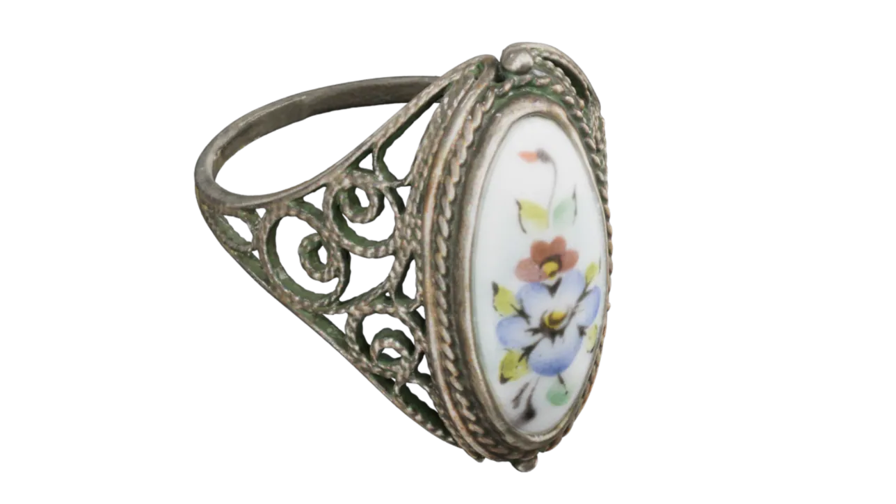 A filigree ring with a hand-painted floral cabochon, captured in full colour